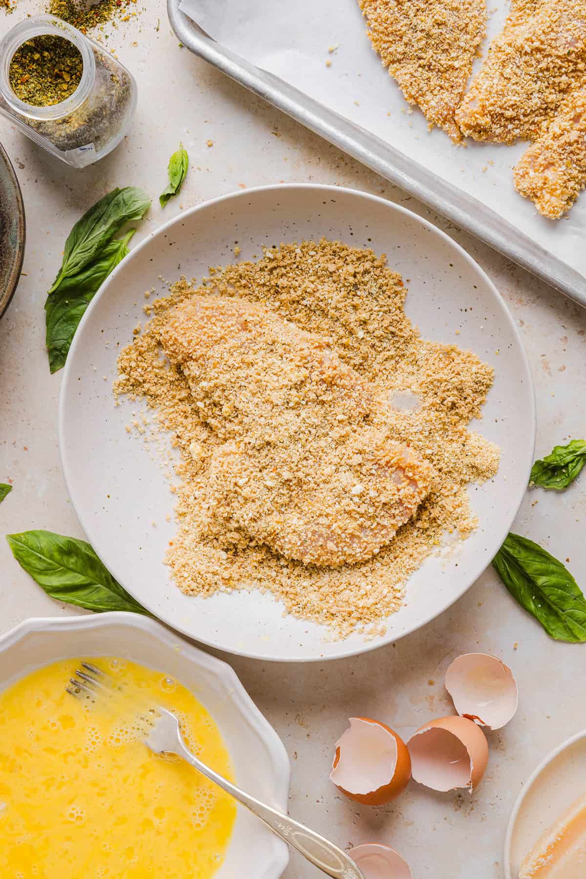 Easy Baked Chicken Parmesan made with tender juicy chicken, rich marinara sauce and melty cheese with a crisp coating that tastes delicious! This chicken is baked, not fried, and easily comes together in under 30 minutes!