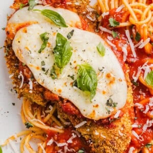Easy Baked Chicken Parmesan made with tender juicy chicken, rich marinara sauce and melty cheese with a crisp coating that tastes delicious! This chicken is baked, not fried, and easily comes together in under 30 minutes!