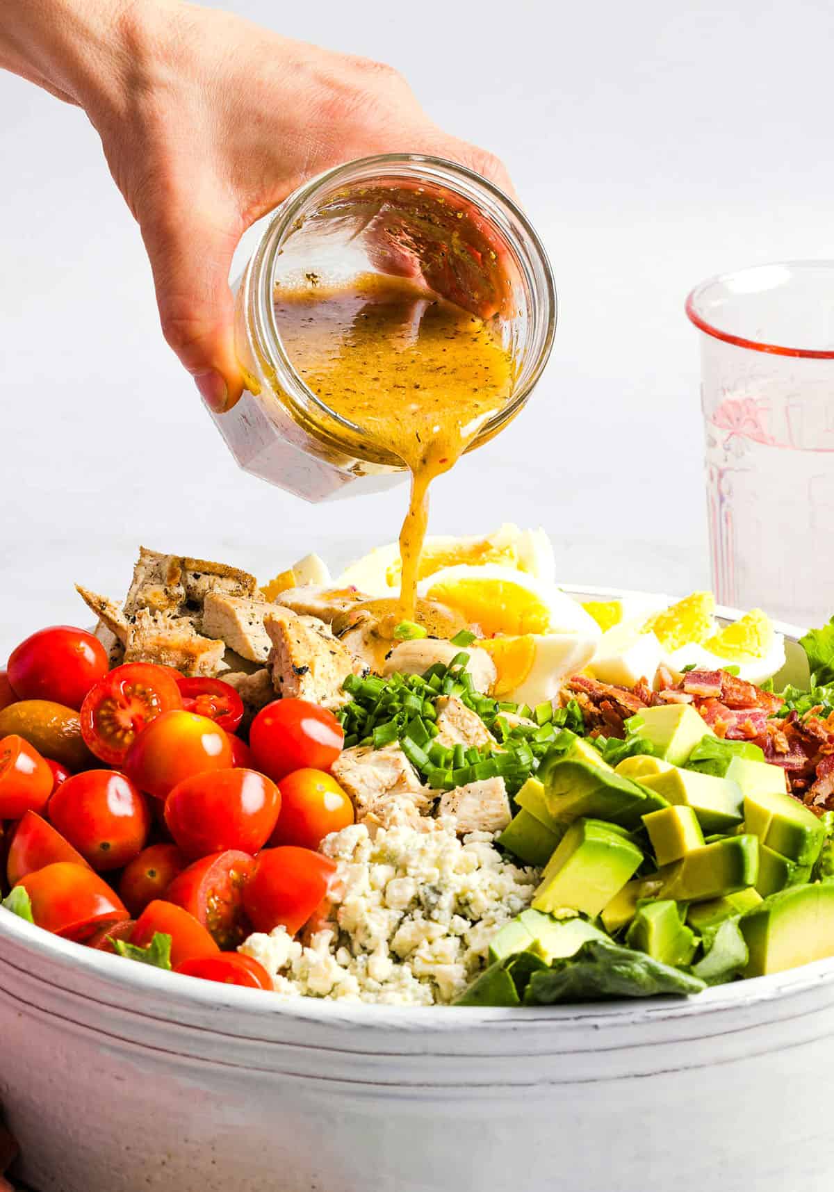 Protein-packed Chicken Cobb Salad loaded with tender chicken, crispy bacon, creamy avocado and tangy blue cheese all tossed in a delicious red wine vinaigrette! A fresh, hearty and satisfying salad that is perfect for lunch or a light dinner.