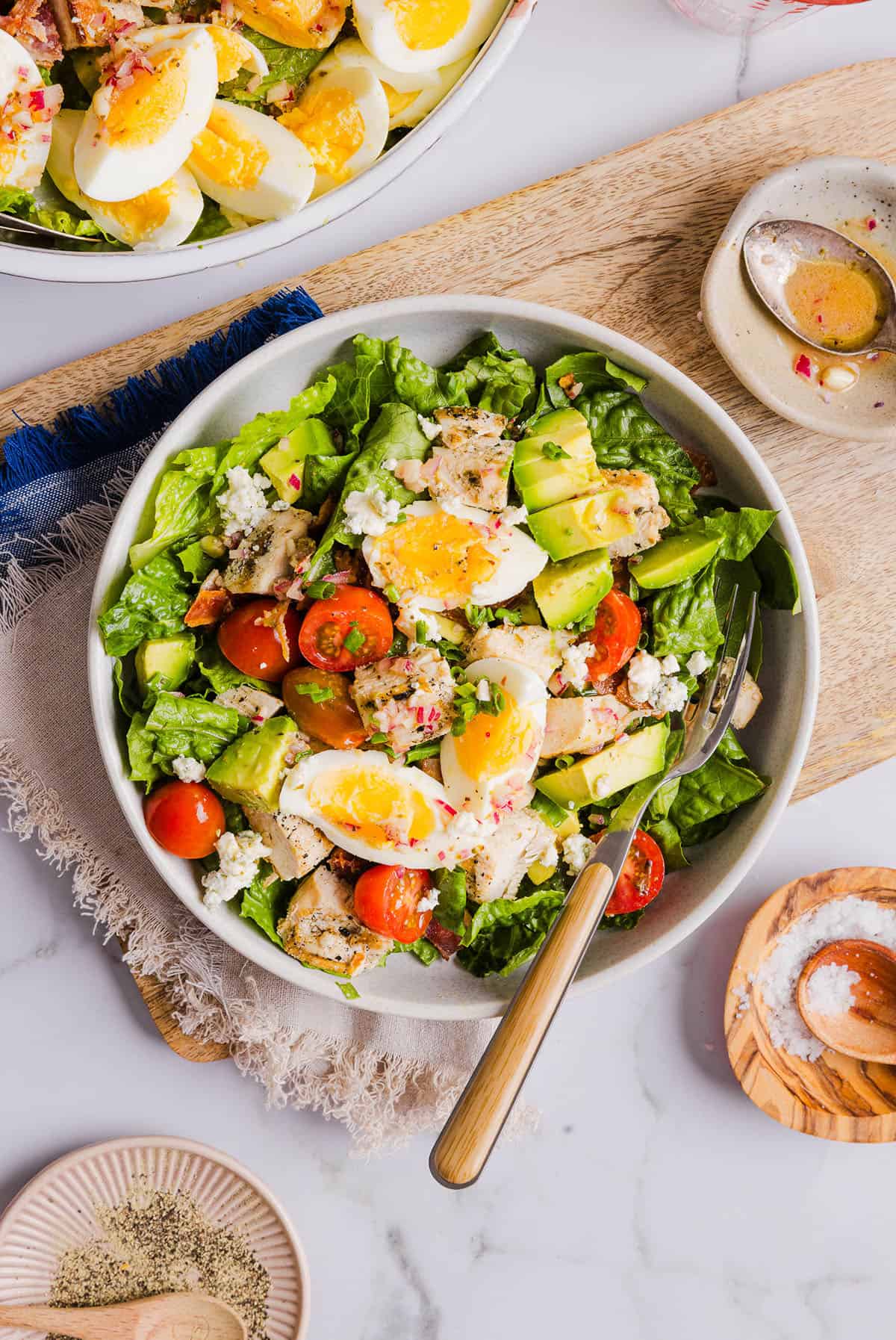 Protein-packed Chicken Cobb Salad loaded with tender chicken, crispy bacon, creamy avocado and tangy blue cheese all tossed in a delicious red wine vinaigrette! A fresh, hearty and satisfying salad that is perfect for lunch or a light dinner.