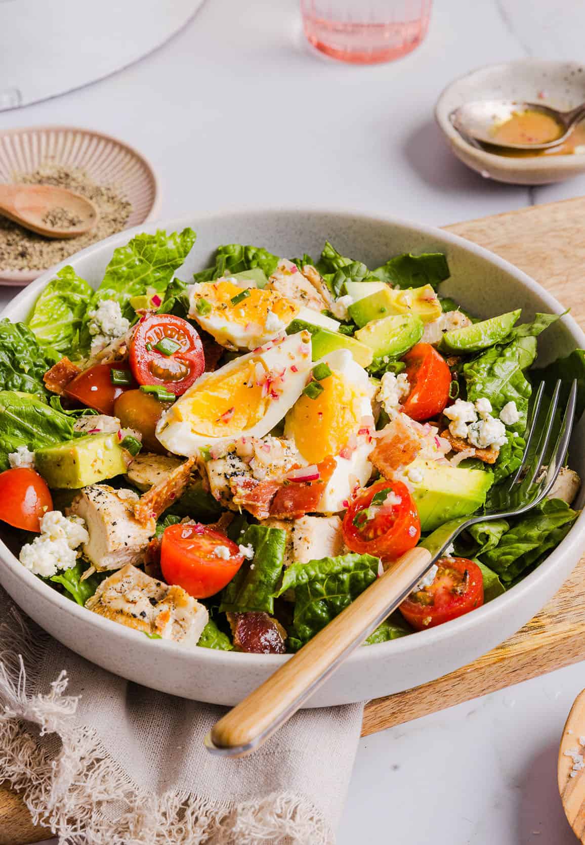 Protein-packed Chicken Cobb Salad loaded with tender chicken, crispy bacon, creamy avocado and tangy blue cheese all tossed in a delicious red wine vinaigrette! A fresh, hearty and satisfying salad that is perfect for lunch or a light dinner.