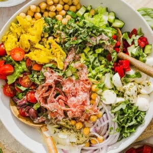 This Italian Chopped Salad recipe tastes just like your favorite grinder, but lighter and SO good! Loaded with crisp lettuce, savory salami, chickpeas, fresh veggies and the best homemade dressing, all finely chopped so you get the perfect bite every time!