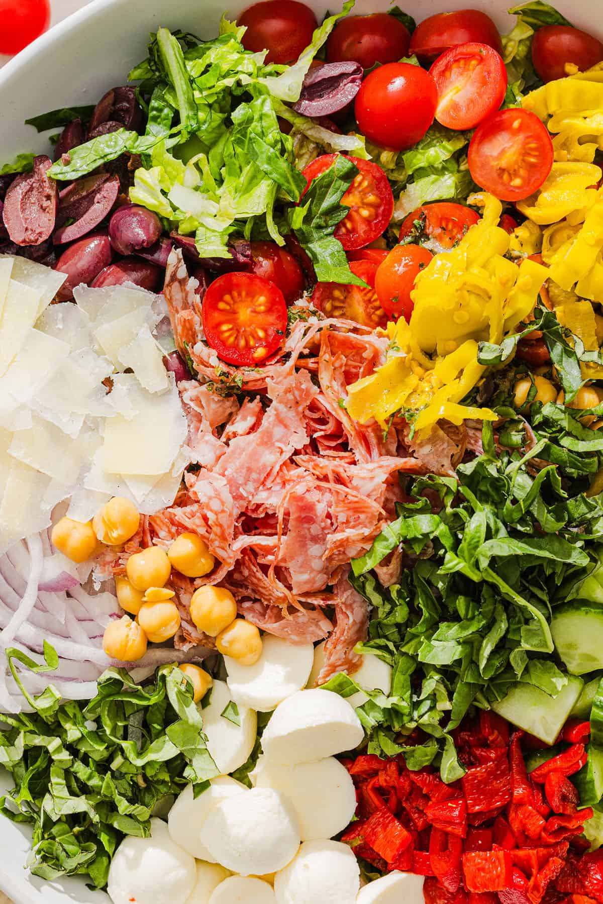 This Italian Chopped Salad tastes just like your favorite grinder, but lighter and SO good! Loaded with crisp lettuce, savory salami, chickpeas, fresh veggies and the best homemade dressing, all chopped up so you get the perfect bite every time!